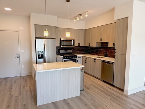 A kitchen with a white counter and wooden cabinets.