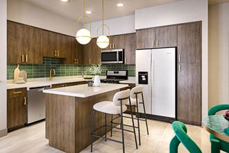 Kitchen in emerald scheme with island seating at Bevel Apartments in San Diego CA