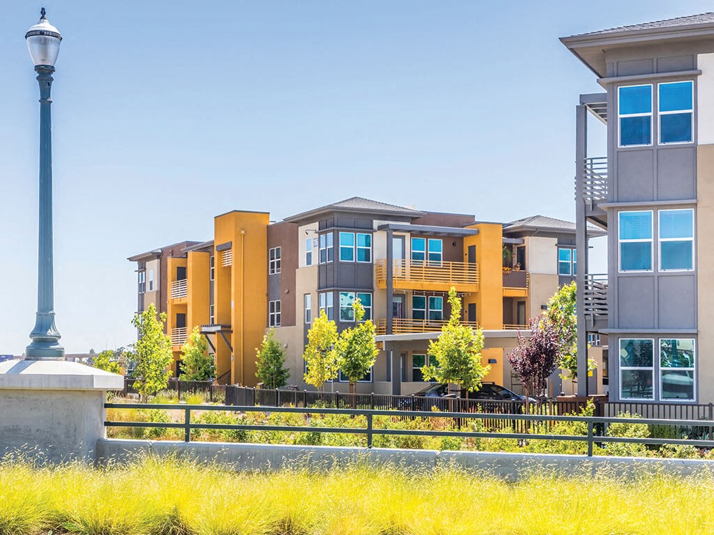 an exterior view of an apartment complex with a lamp post in the foreground