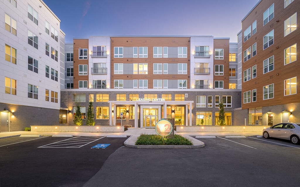 a parking lot in front of an apartment building at night