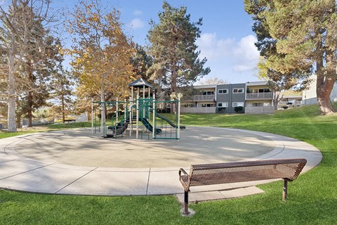 A park with a playground and a bench.
