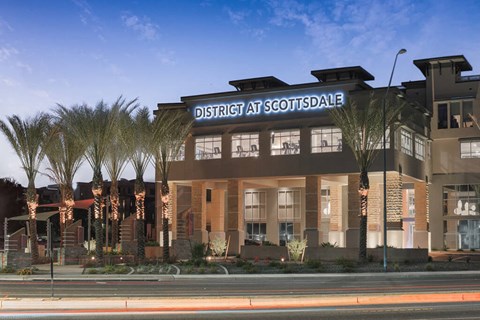 Exterior sign lit up at night at District at Scottsdale Apartments in Scottsdale AZ
