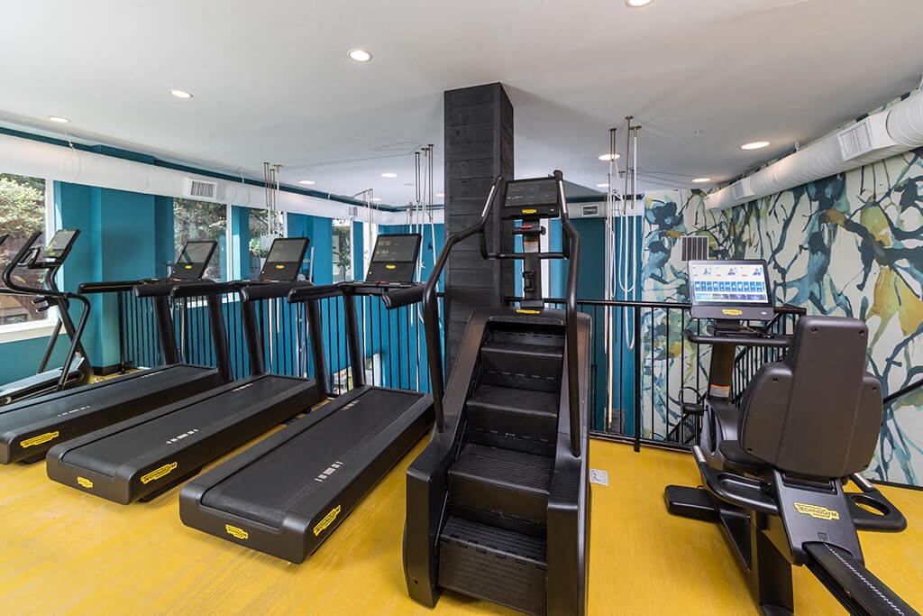 a room with a bunch of treadmill machines in it