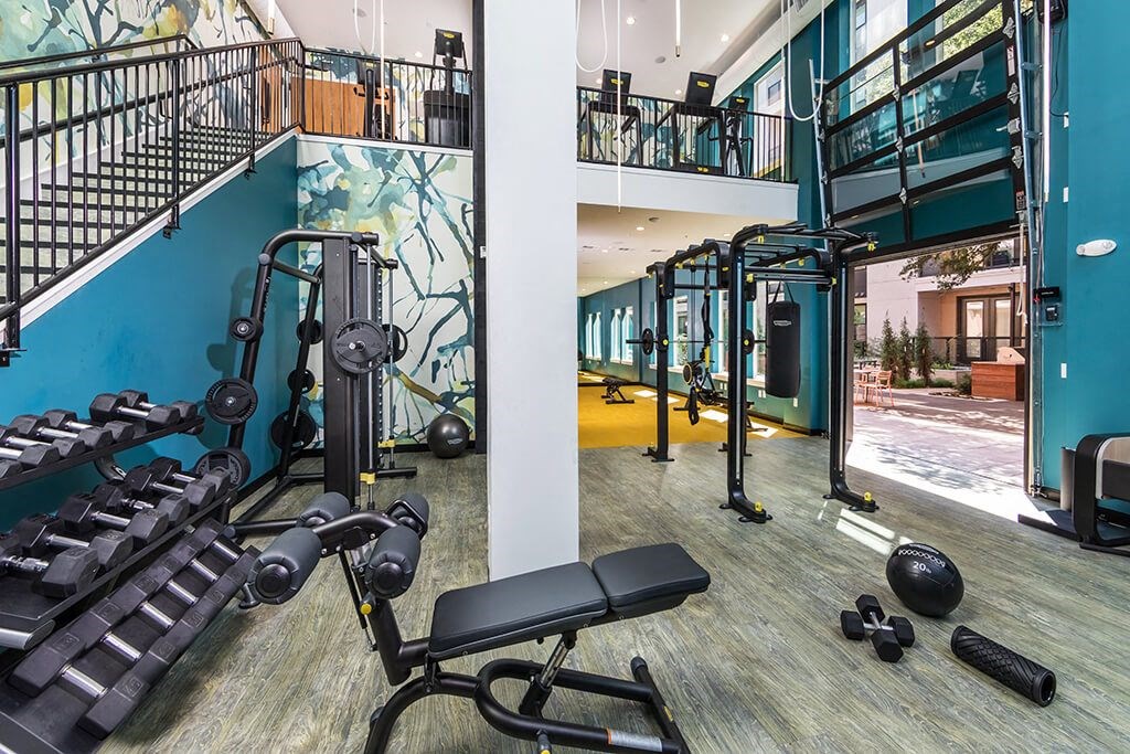 a workout room with weights and cardio equipment at aria on the avenue apartments