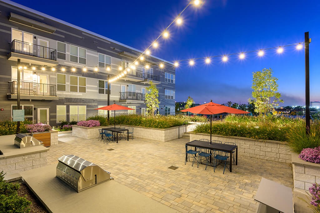 a patio with tables and umbrellas at night