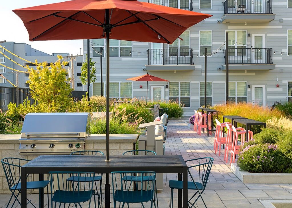 a patio with tables and chairs and umbrellas