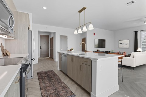 A modern kitchen with a white refrigerator and a white island.
