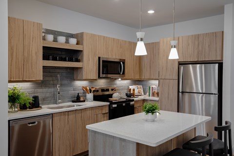 A modern kitchen with wooden cabinets and stainless steel appliances.