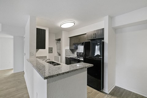 a kitchen with black appliances and a granite counter top