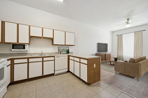A kitchen with white cabinets and a microwave.