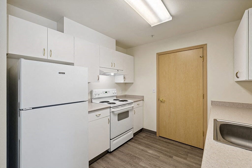 a kitchen with white appliances and white cabinets