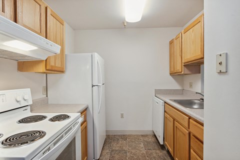 a kitchen with white appliances and wooden cabinets and a white refrigerator