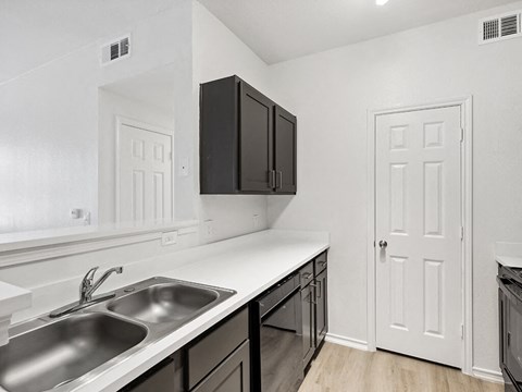the kitchen of our studio apartment atrium with stainless steel appliances and black cabinets