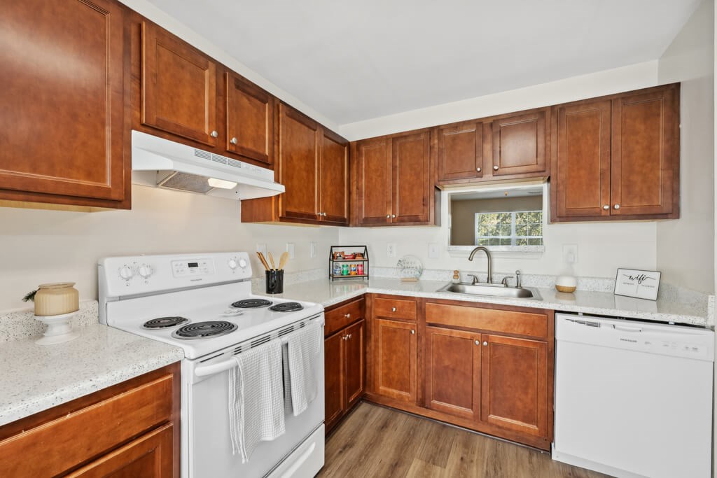 a kitchen with white appliances and wooden cabinets