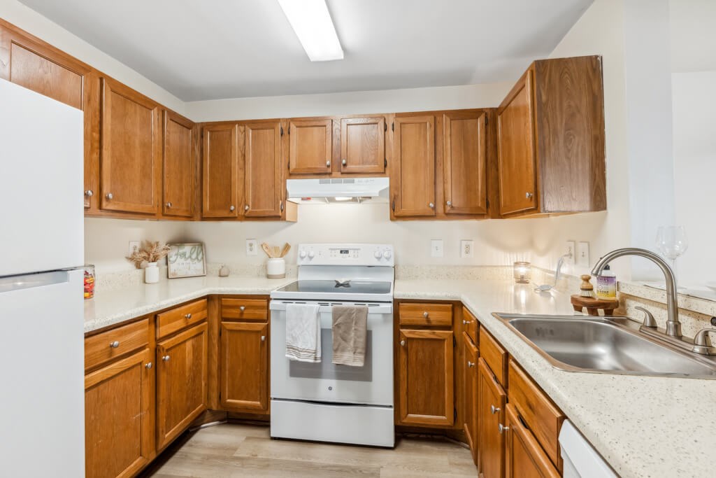 a kitchen with wooden cabinets and white appliances