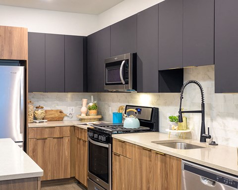 a kitchen with black cabinets and a sink