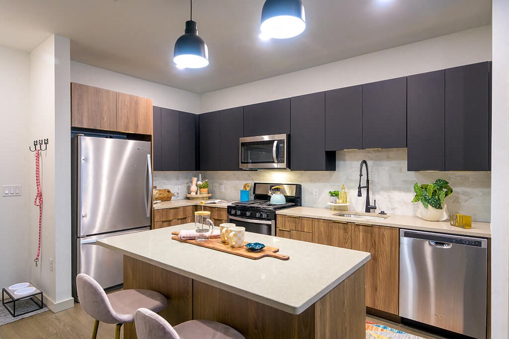 a kitchen with a large island and a stainless steel refrigerator
