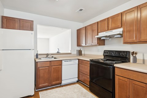A kitchen with a black stove top oven and white appliances.