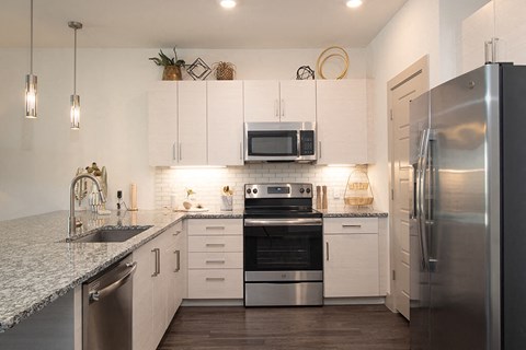 Kitchen with white cabinets and seating at District at Scottsdale Apartments in Scottsdale AZ