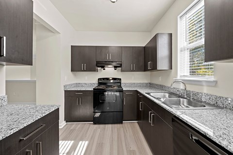 a kitchen with granite counter tops and black appliances