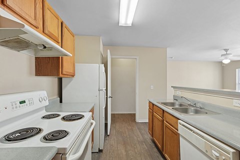 A kitchen with a white stove top oven and a white refrigerator.