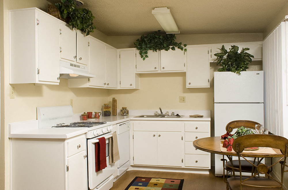 a kitchen with white cabinets and a table