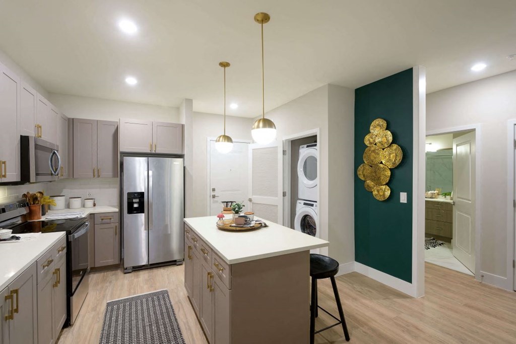 Kitchen with an island and a stainless steel refrigerator