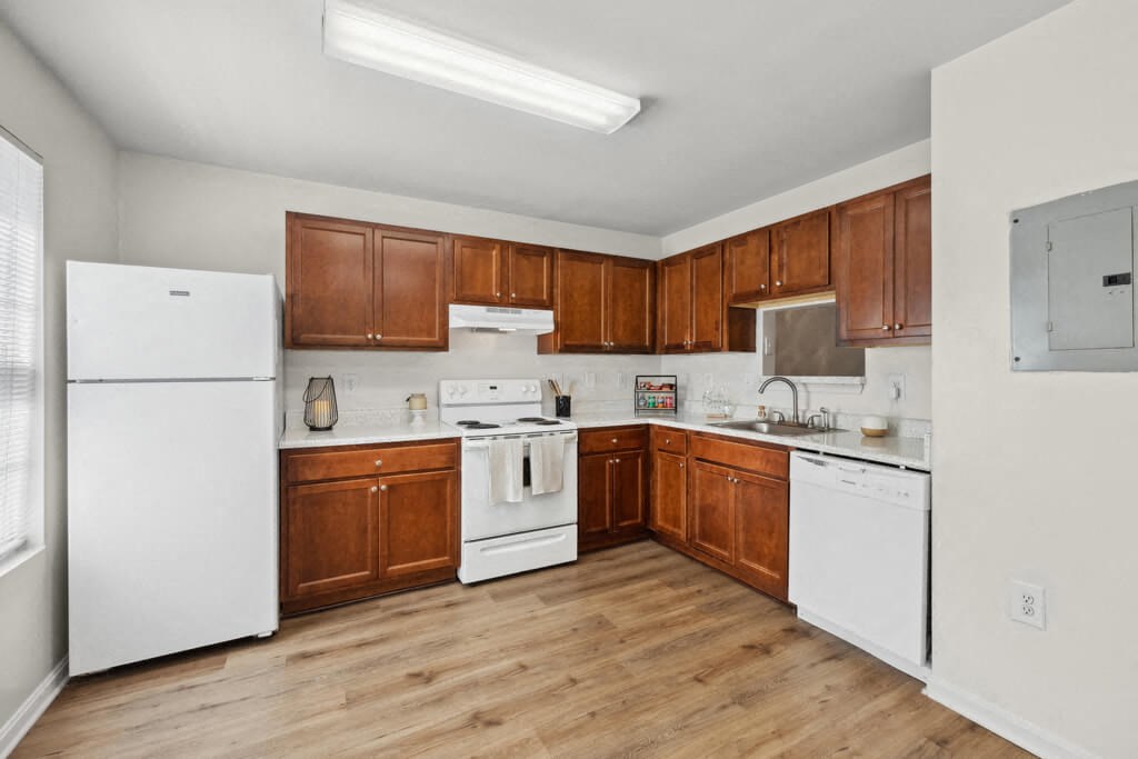 a kitchen with white appliances and wooden cabinets