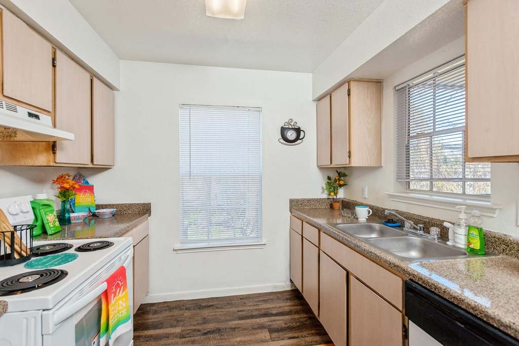 Kitchen galley with windows and appliances at Park Village Apartments in Conroe TX