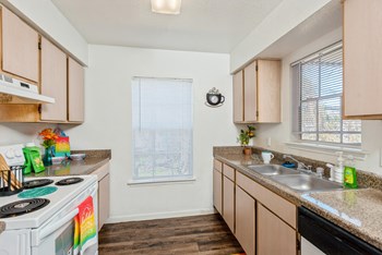 Kitchen galley with windows and appliances at Park Village Apartments in Conroe TX - Photo Gallery 3