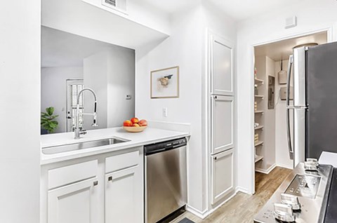 A modern kitchen with white cabinets and stainless steel appliances.