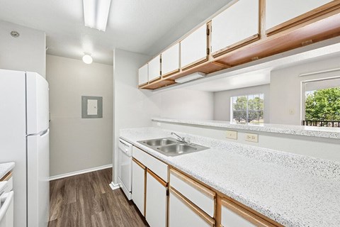 A kitchen with white cabinets and a white fridge.