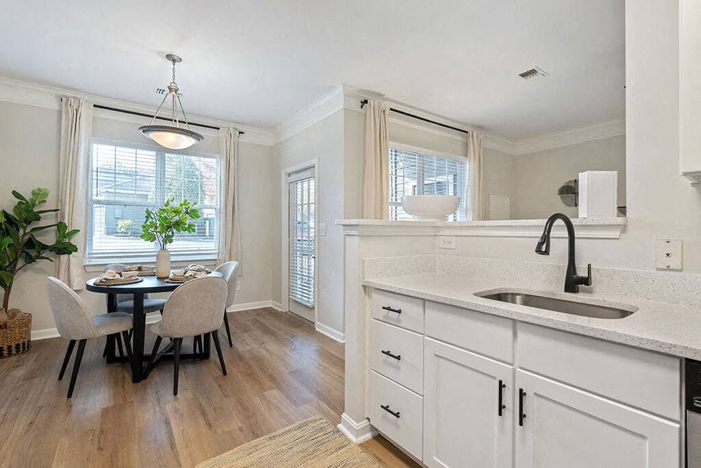 a kitchen with a sink and a table with chairs