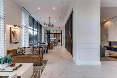 A modern living room with a brown sofa and a chandelier.