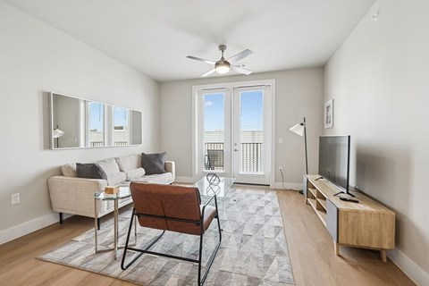 Living room with ceiling fan at The Sevens in Dallas TX