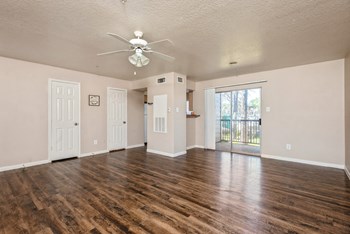 Living room with ceiling fan and hardwood flooring at Park Village Apartments in Conroe TX - Photo Gallery 4