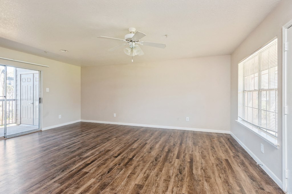 Living room with attached patio at Park Village Apartments in Conroe TX