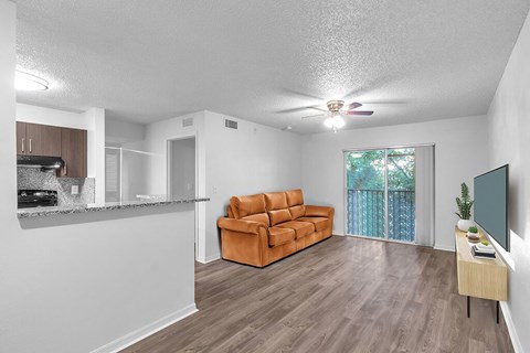 A living room with a brown couch and a flat screen TV.