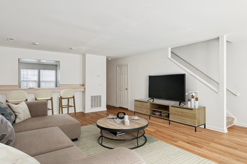 A living room with a couch, a coffee table, and a television.