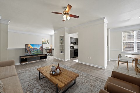 A living room with a brown coffee table and a painting on the wall.