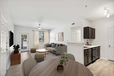 A modern living room with a wooden table and grey couches.
