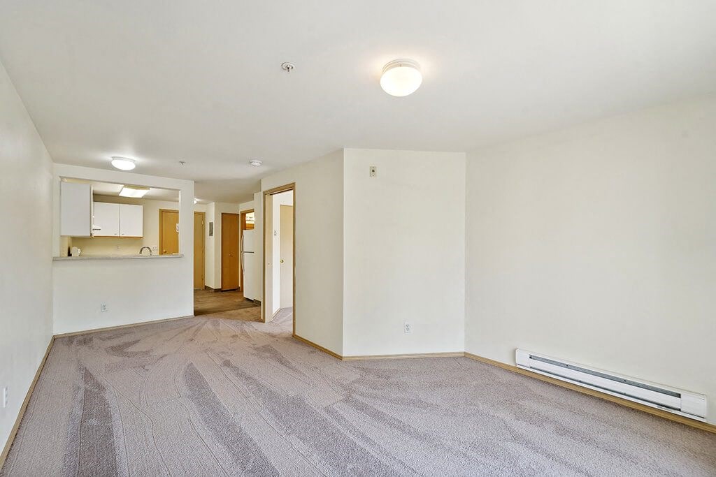 Living room with wood style flooring at Woodlands at Forbes Lake Apartments in Kirkland WA