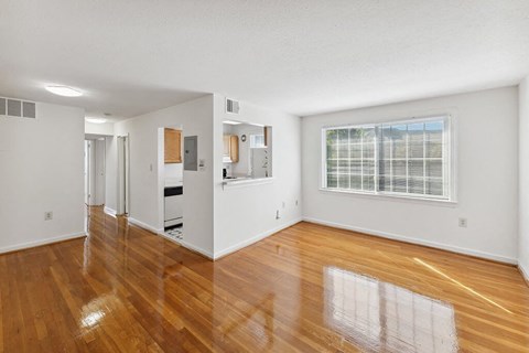 an empty living room with wood floors and a window