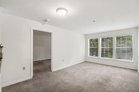 an empty living room with a large window and a door