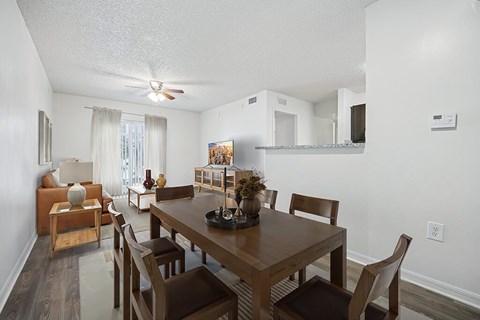 A dining room with a wooden table and chairs.