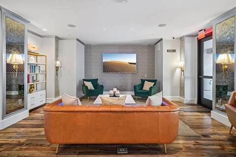 A living room with a brown sofa and a painting on the wall.