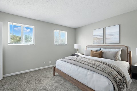 A bedroom with a large bed and two pictures on the wall.
