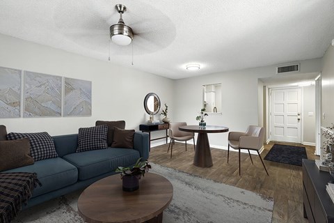 A living room with a blue couch, a coffee table, and a rug.