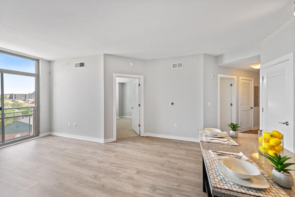 Model living area with wood style flooring at Bradley Braddock Road Station Apartments in Alexandria VA