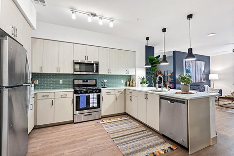 a kitchen with white cabinets and stainless steel appliances